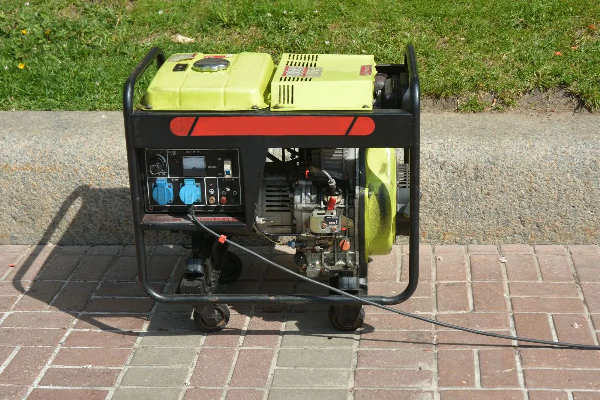 Portable standby generator being serviced on a paved driveway